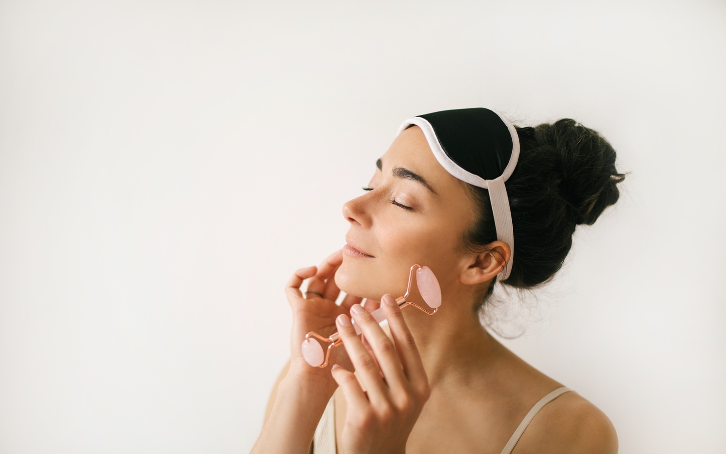 Woman Using Rose Quartz Jade Roller