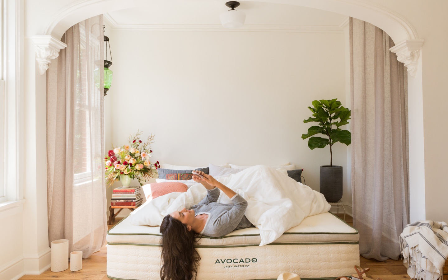 Woman Lying in Bed Looking at Phone