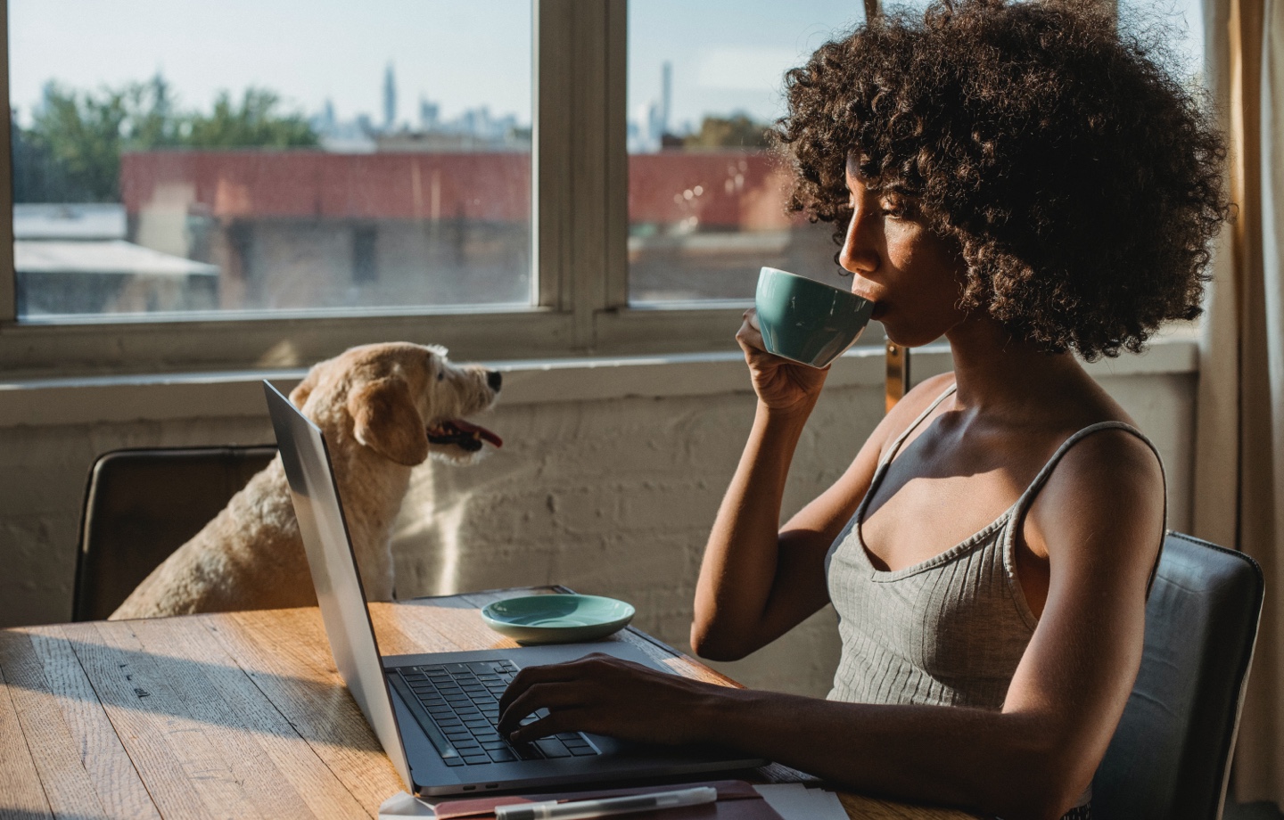Woman Drinking Coffee While At Laptop