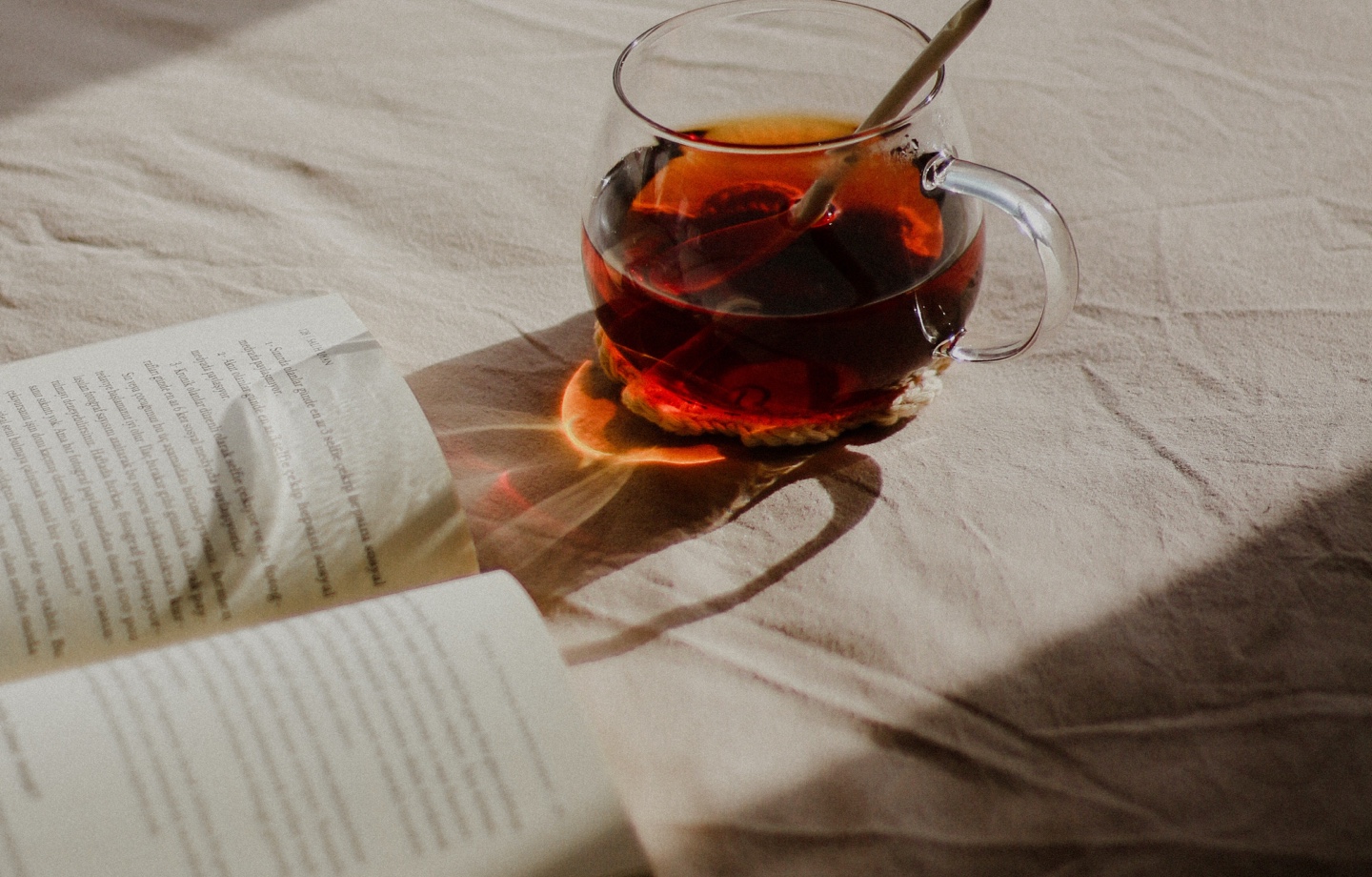 open book and cup of tea in bed
