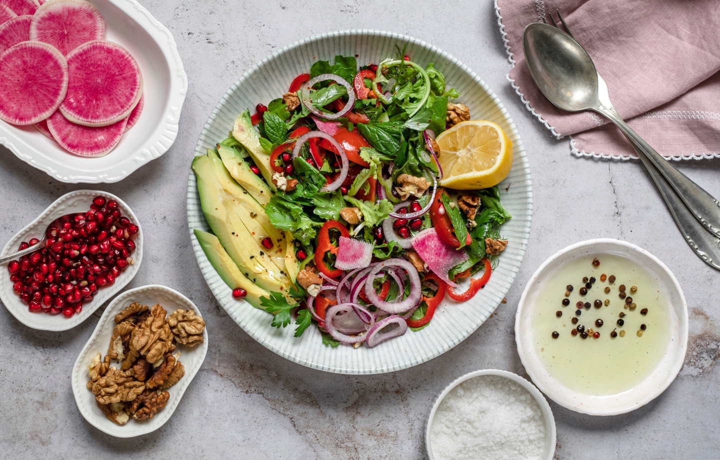salad with lettuce radishes, pomegranate, avocado, walnuts, lemon and more
