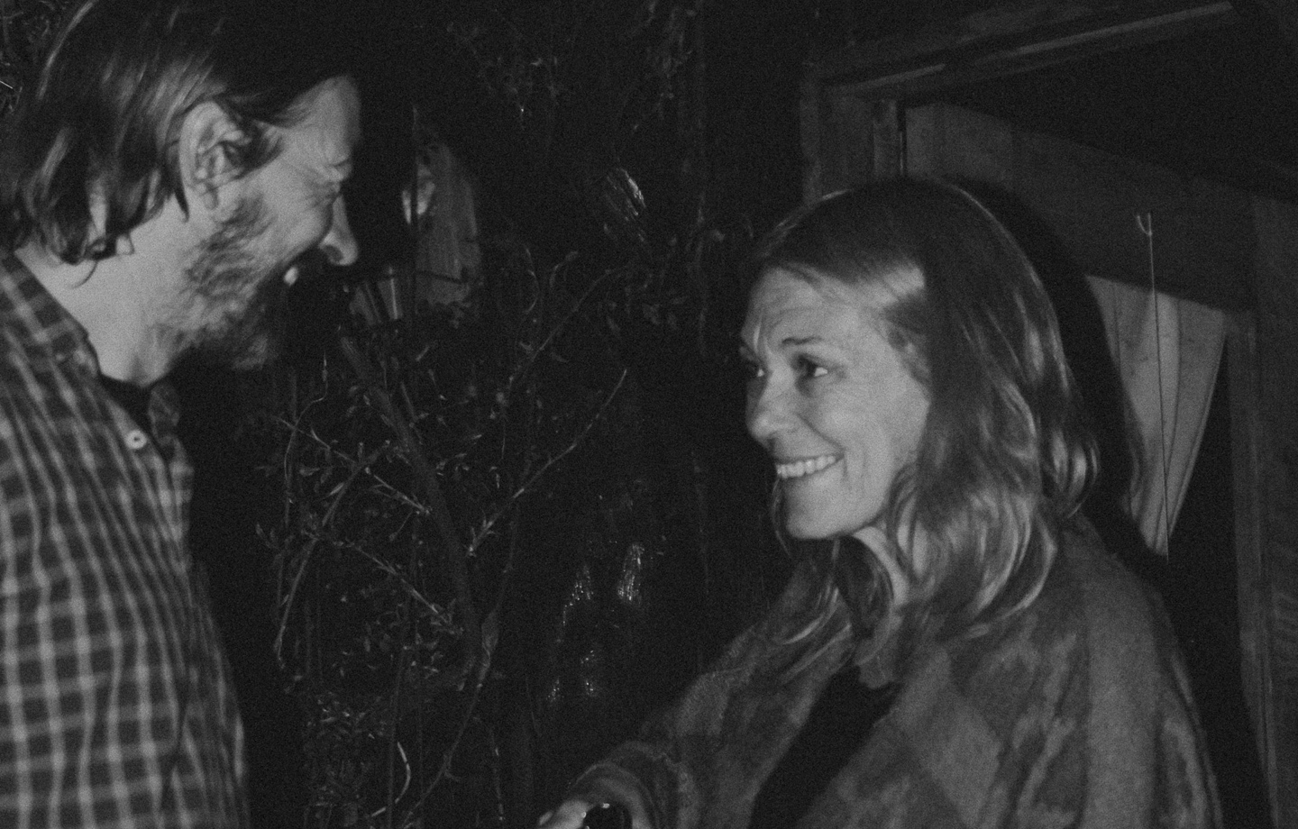 grainy black and white photo of a man and woman talking outside