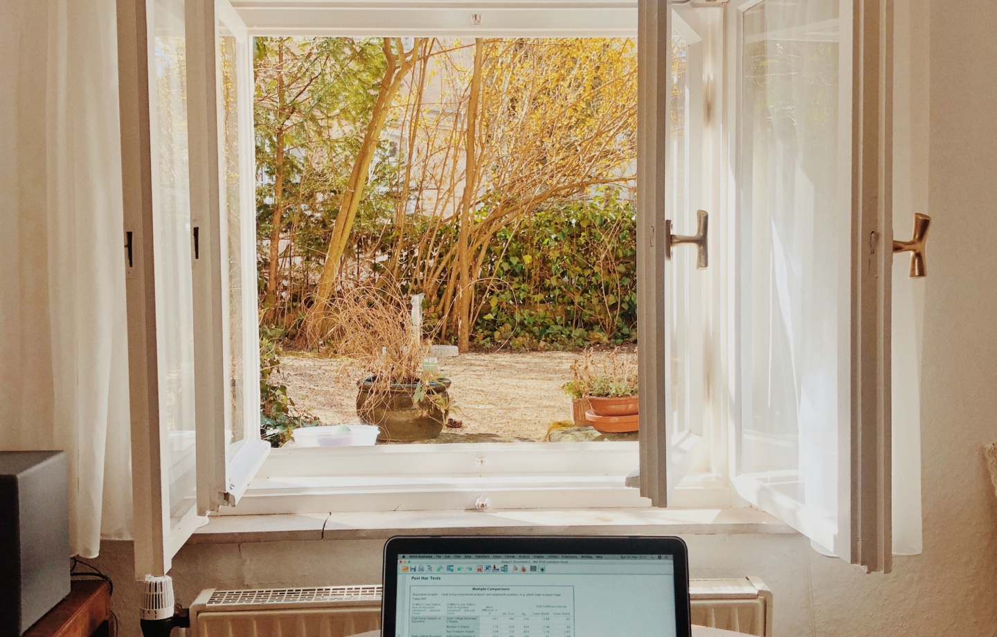 laptop on table in front of open window
