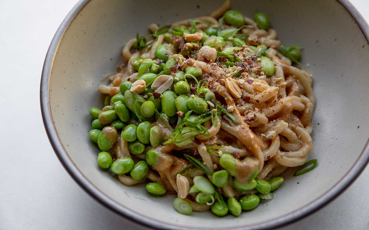 close up of peanut noodles in a bowl