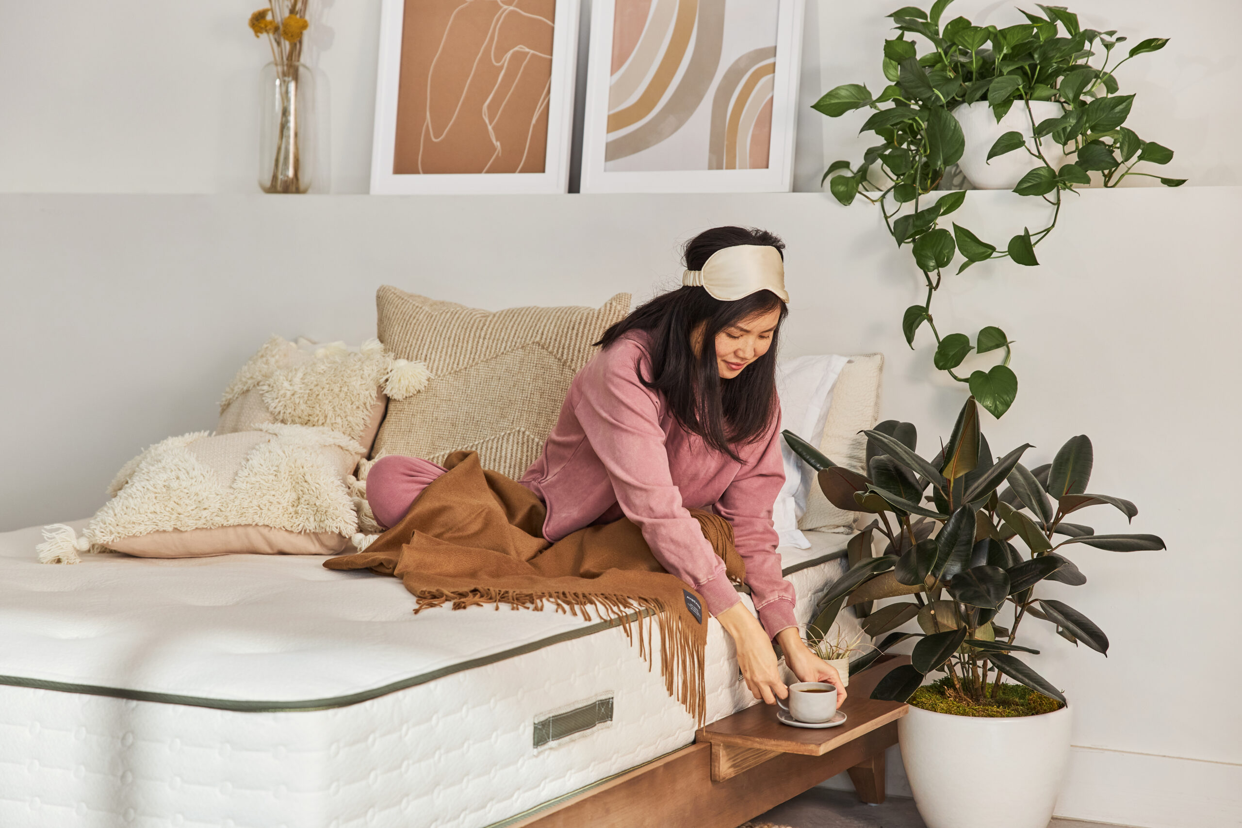 woman picking up cup of coffee off of side table