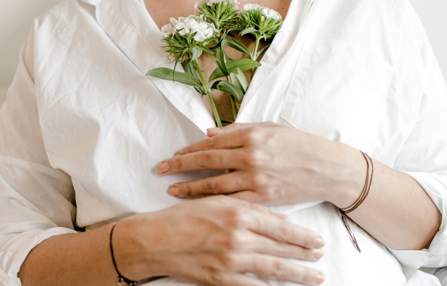 pregnant woman holding bundle of white flowers