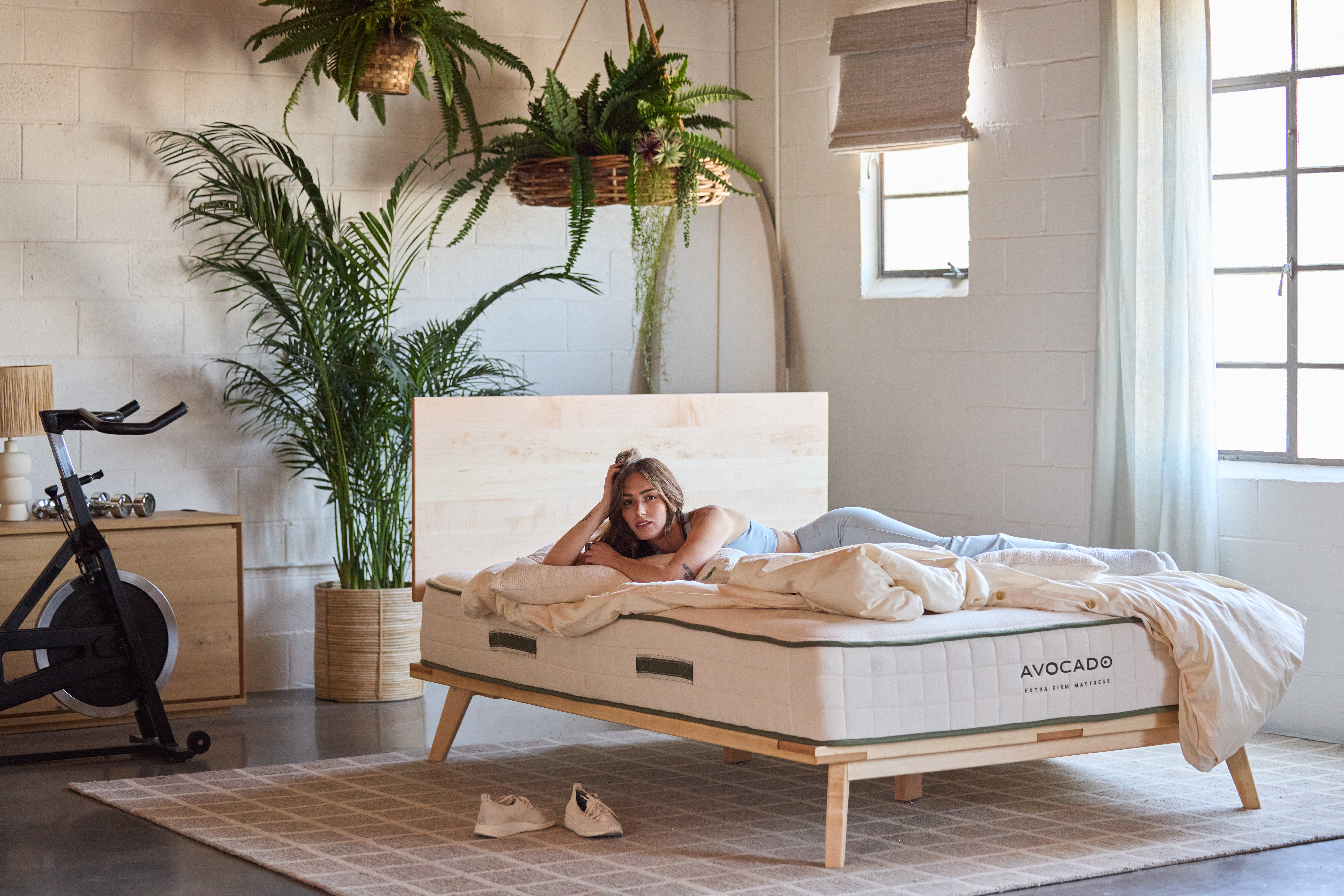Woman laying on Avocado Extra Firm Mattress and Mid Century Bed Frame