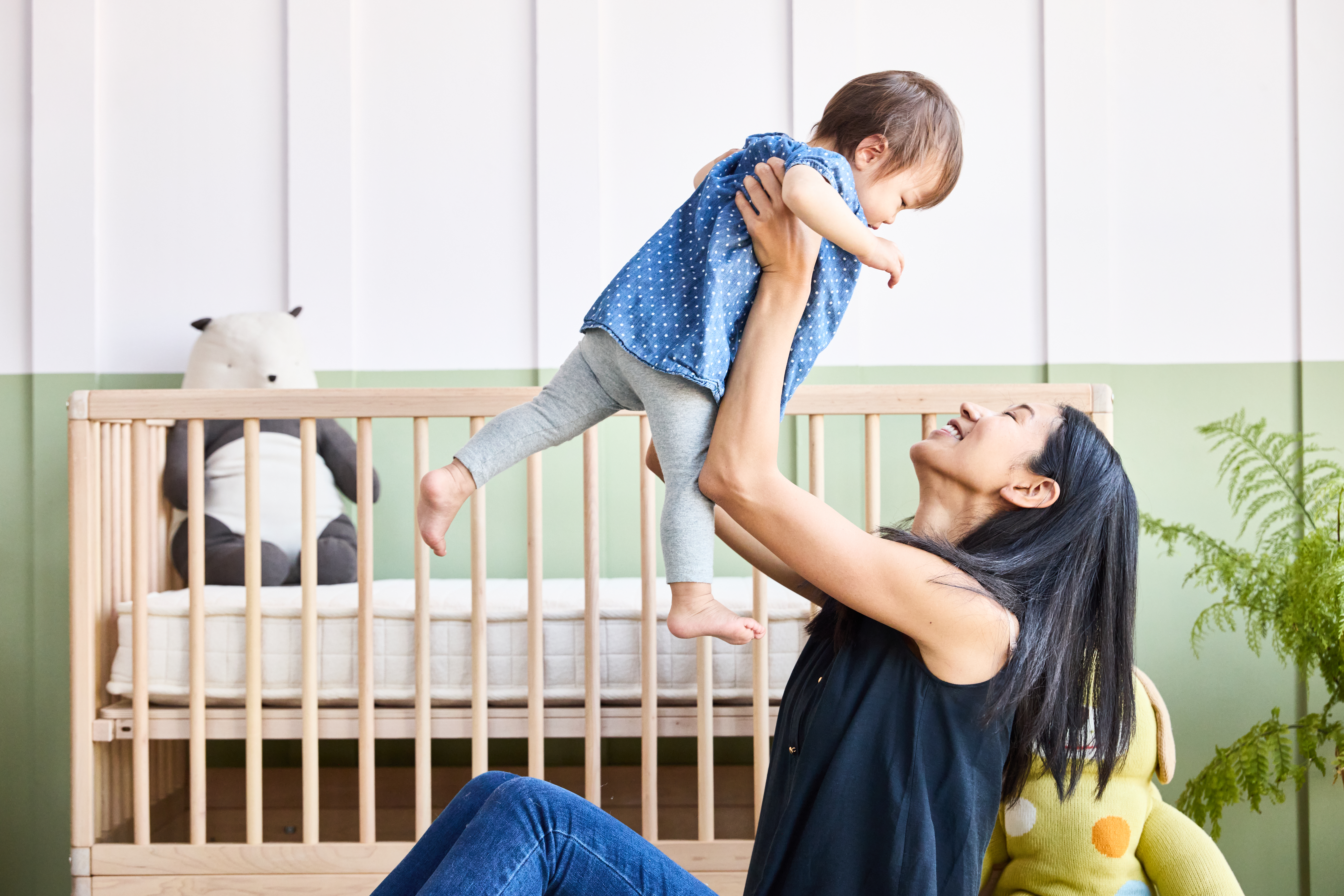 Mother and baby in front of crib