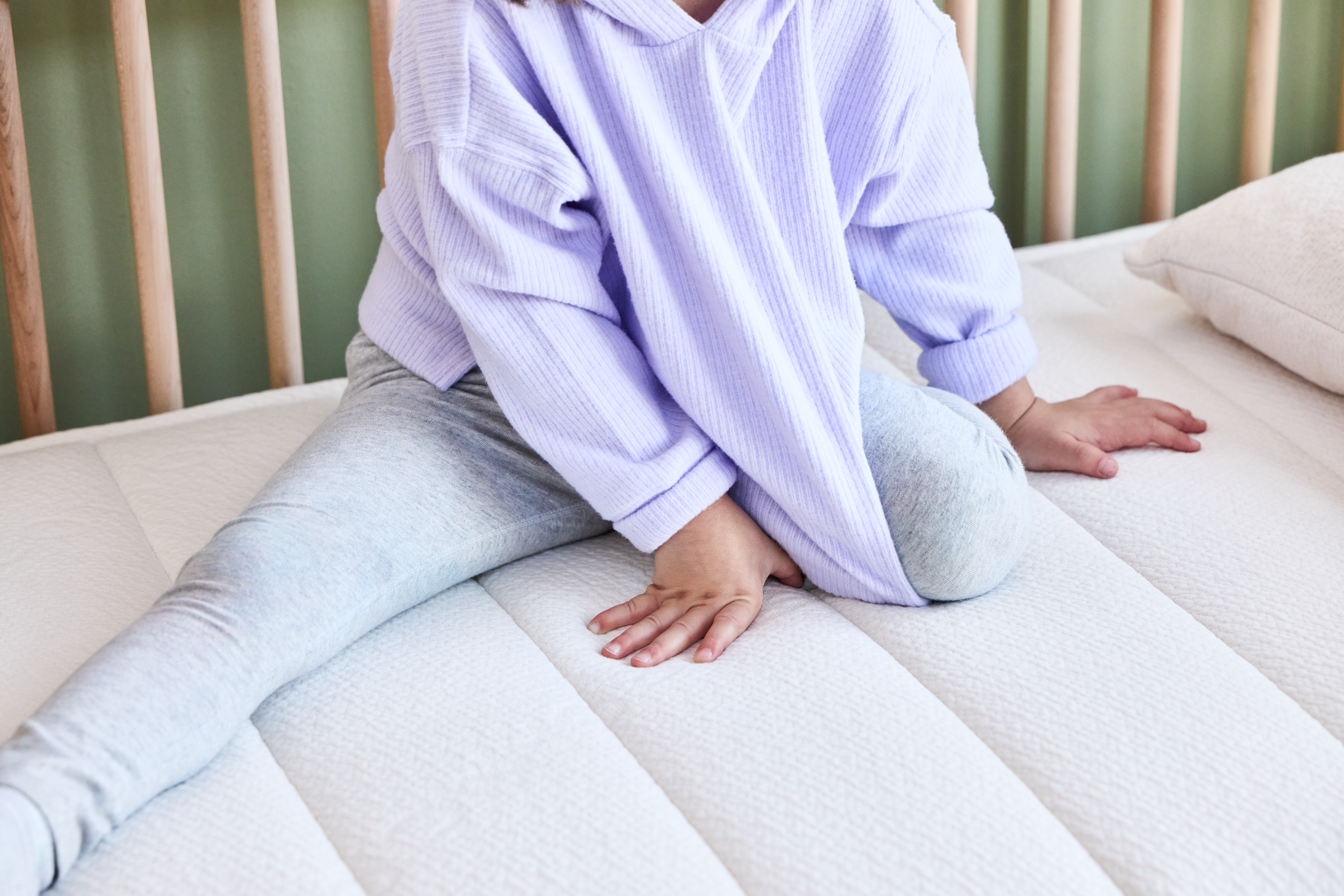 Baby sitting on crib